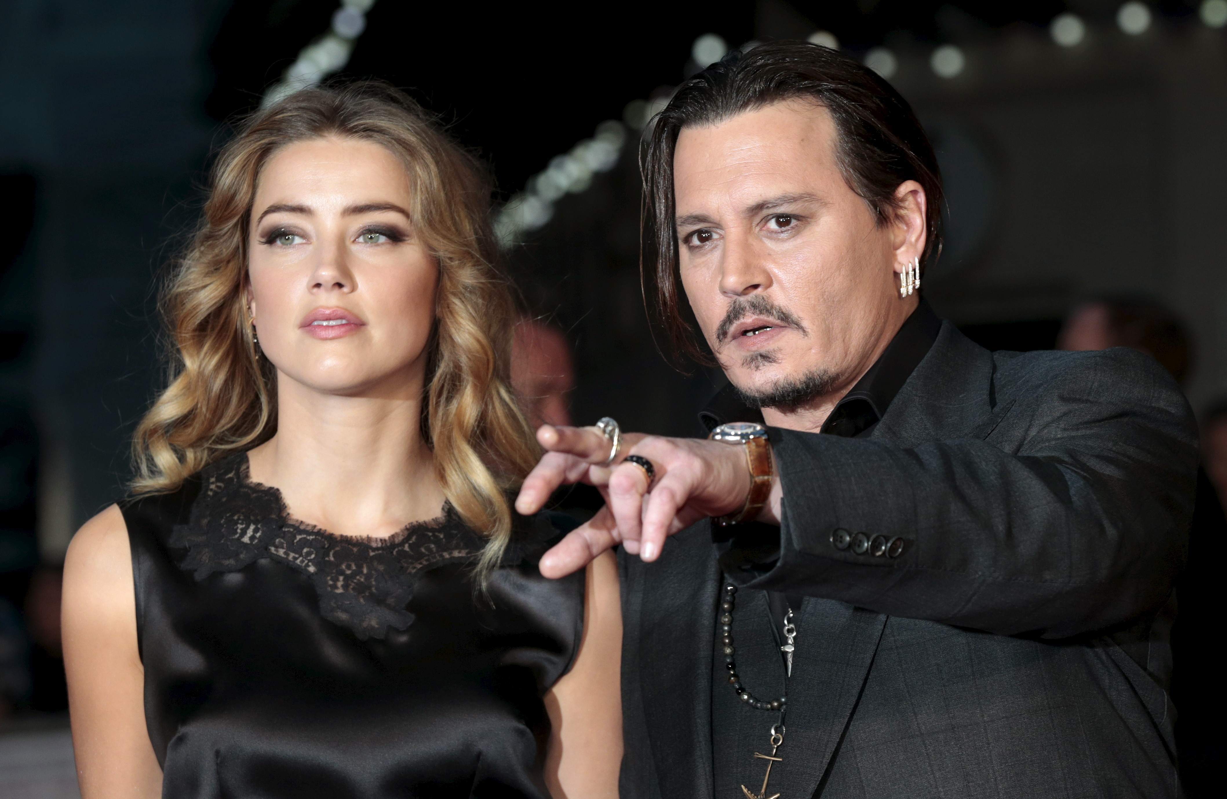 Cast member Johnny Depp and his actress wife Amber Heard arrive for the premiere of the British film "Black Mass" in London, Britain October 11, 2015. REUTERS