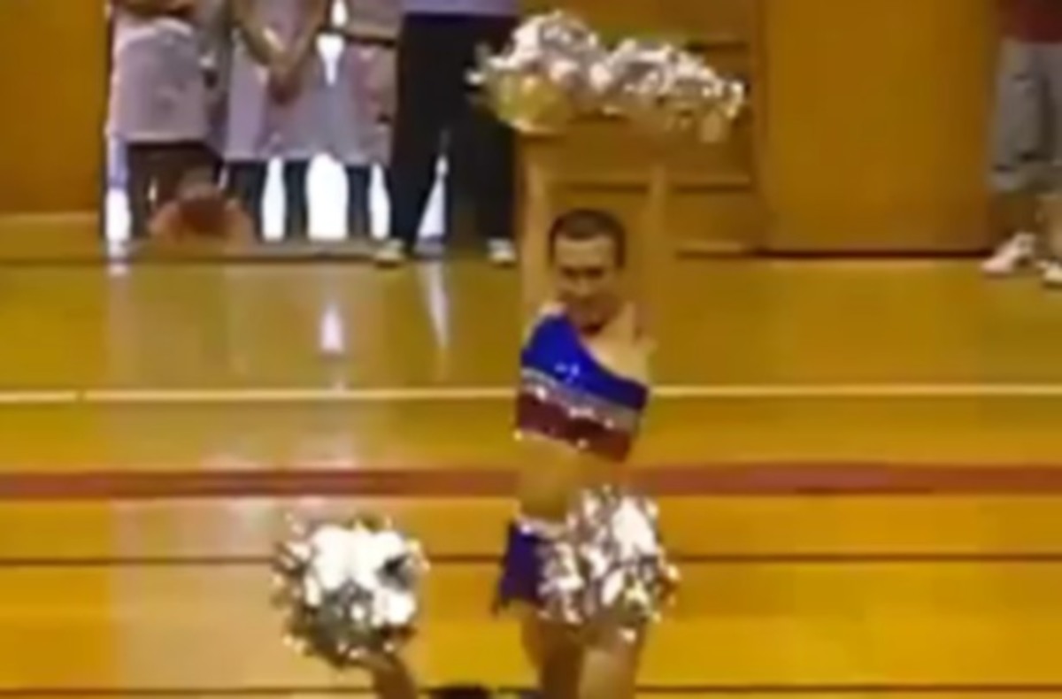 Άντρας cheerleader με φούστα και πομ πομ