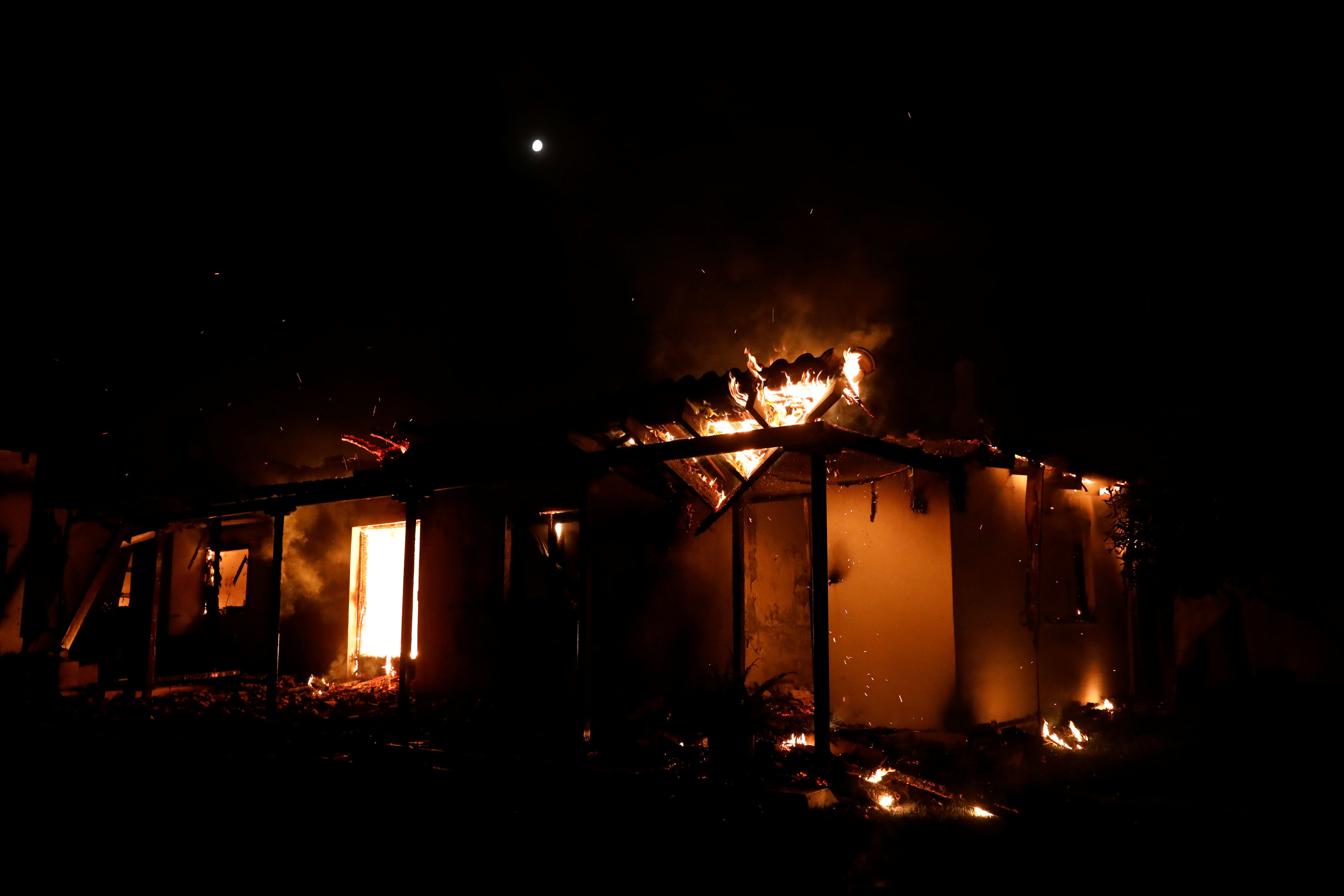 A house burns as a wildfire rages at the village of Mati, near Athens, Greece, July 23, 2018. REUTERS